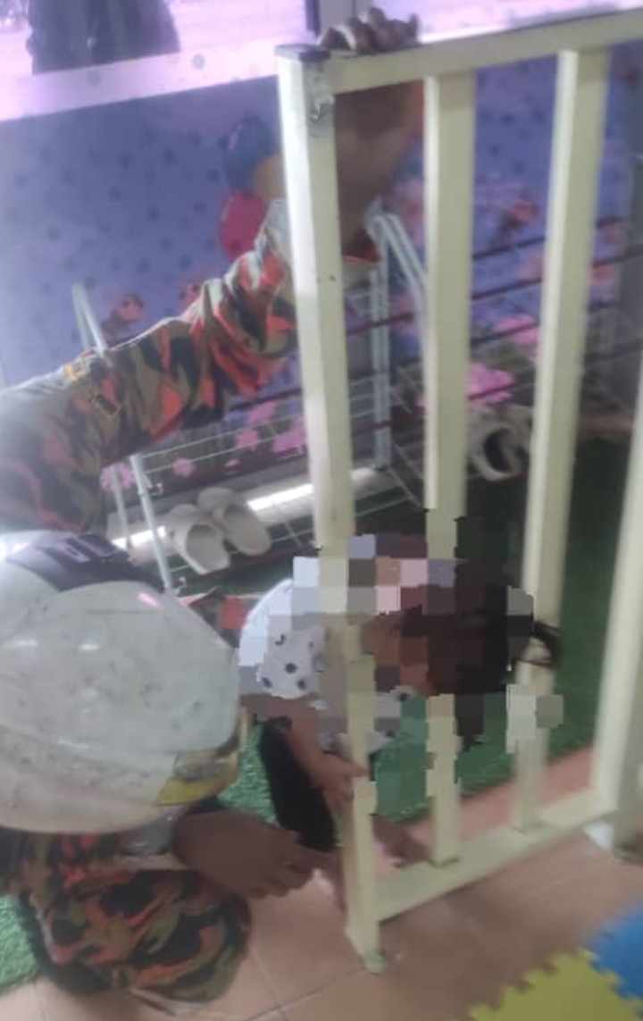 Kepala budak perempuan tersepit di penghadang besi
